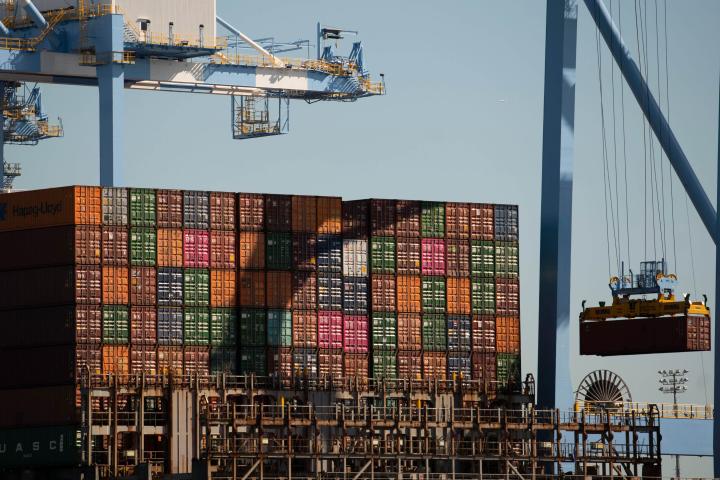 Cranes lifting containers from a ship.